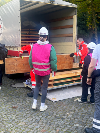 Personen die Biertisch-Ganituren auf einen LKW laden